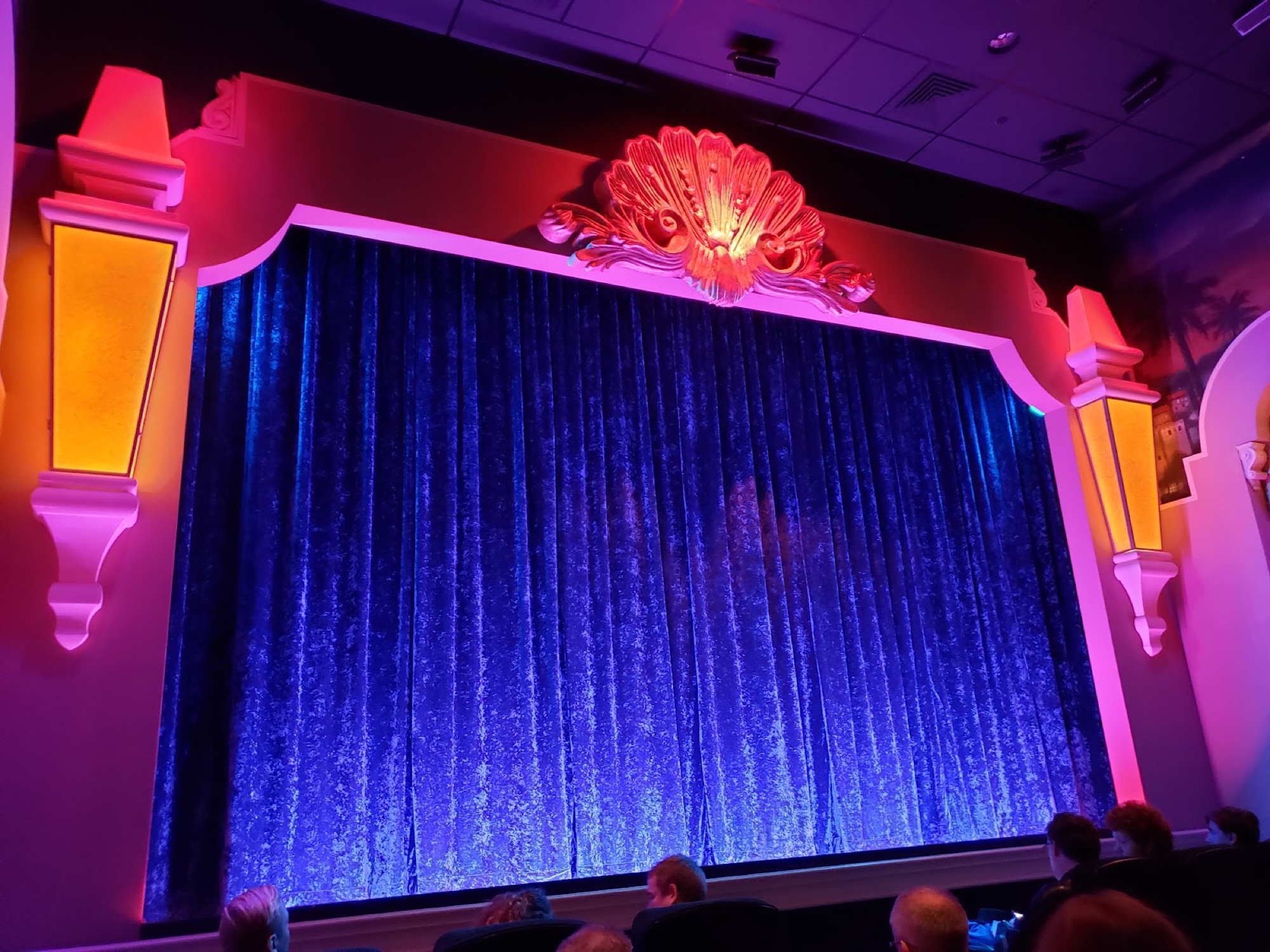 An ornate plaster crest crowning a stage curtain, awaiting restoration